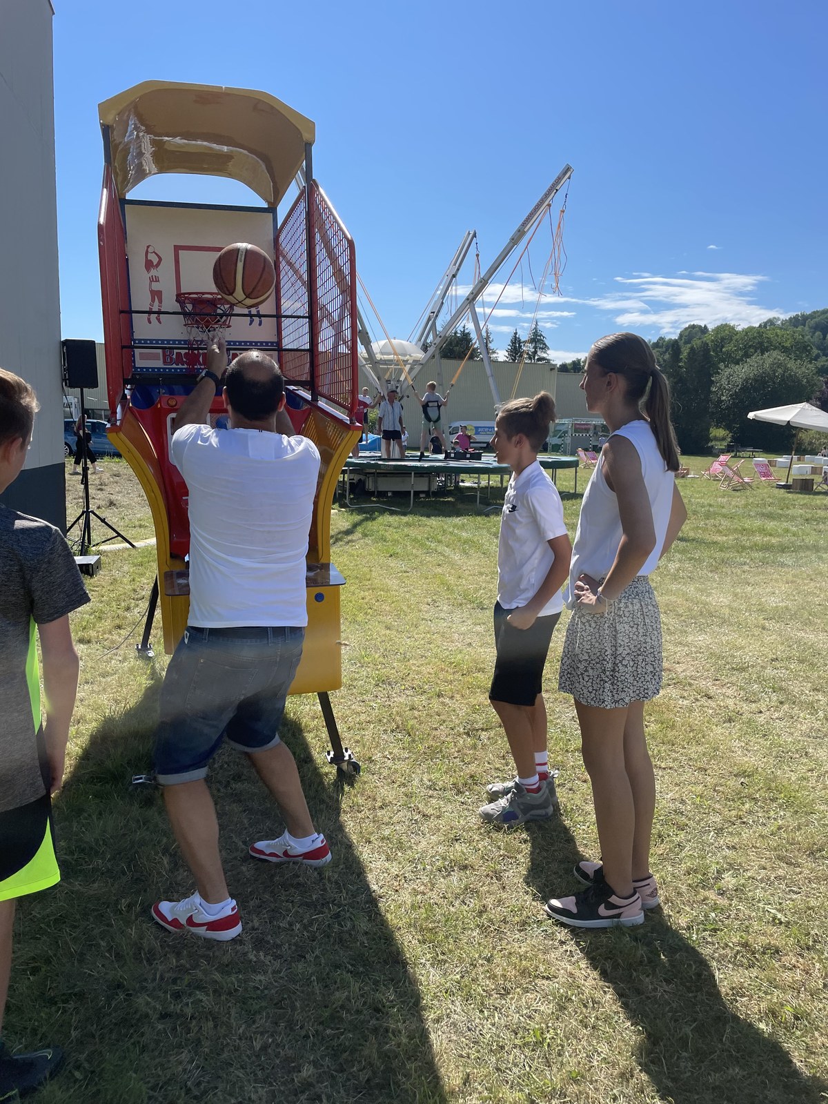 Outdoor-Spielstation mit Basketball-Automat und Bungee-Trampolin bei einem Firmensommerfest — AchtWerk Event